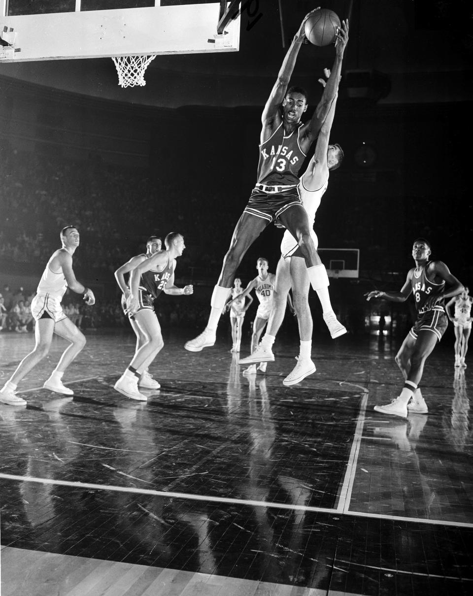 FILE - University of Kansas center Wilt Chamberlain (13), grabs a rebound in front of Oklahoma's Bill Ashcraft in a Big Seven Tournament game in Kansas City, Mo., Dec. 28, 1956. In left foreground is Lewis Johnson and at right is Maurice King, both of Kansas. Chamberlain scored 36 points for Kansas in their 74-56 victory. (AP Photo/File)