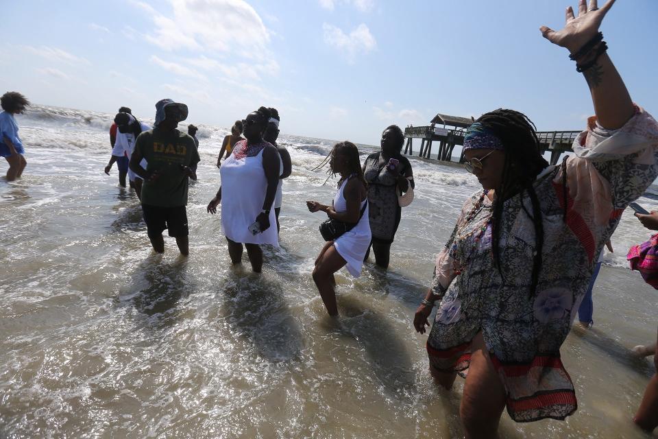 Participants dance in the ocean near the Tybee Island Pier on Sunday during the annual Tybee Juneteenth Wade In.