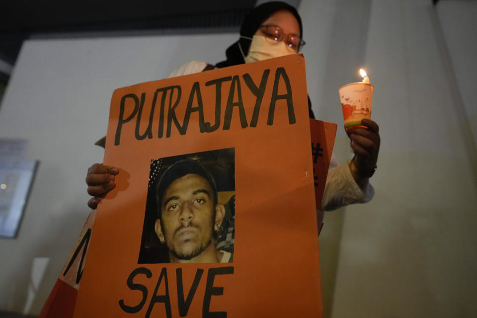 An activist holds a poster against the impending execution of Nagaenthran K. Dharmalingam, sentenced to death for trafficking heroin into Singapore, during a candlelight vigil gathering outside the Singaporean Embassy in Kuala Lumpur, Malaysia, Tuesday, April 26, 2022. The Singapore Court of Appeal has dismissed a last-minute legal challenge filed by the mother of a mentally disabled Malaysian man in an attempt to halt his execution for drug trafficking. (AP Photo/Vincent Thian)