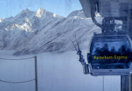 A gondola goes up next to the mountains around Zermatt, Switzerland, Thursday, Dec.3, 2020. Zermatt is home to one of the Swiss ski stations that has become an epicenter of discord among Alpine neighbors. EU member states Austria, France, Germany and Italy are shutting or severely restricting access to the slopes this holiday season amid COVID-19 concerns, Switzerland is not. (AP Photo/Jamey Keaten)