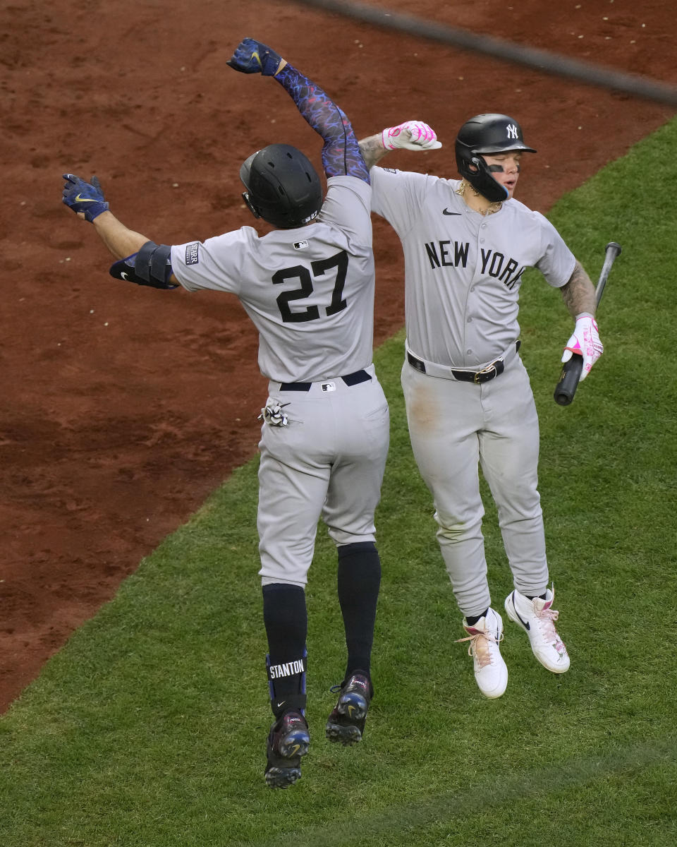 New York Yankees' Giancarlo Stanton (27) celebrates with Alex Verdugo after hitting a two-run home run during the fifth inning of a baseball game against the Kansas City Royals Wednesday, June 12, 2024, in Kansas City, Mo. (AP Photo/Charlie Riedel)