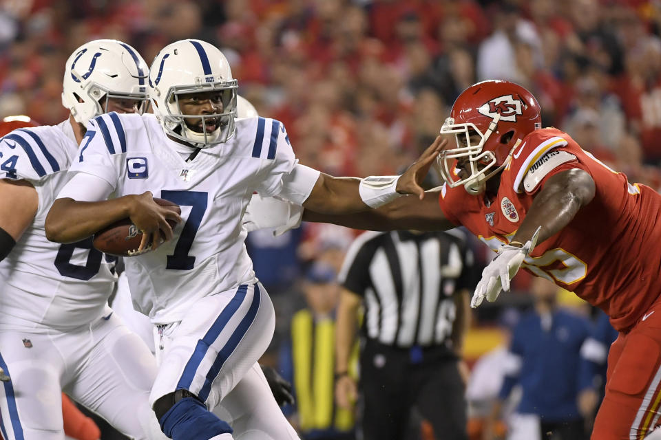 Indianapolis Colts quarterback Jacoby Brissett (7) runs away from pressure by Kansas City Chiefs defensive tackle Chris Jones, right, during the first half of an NFL football game in Kansas City, Mo., Sunday, Oct. 6, 2019. (AP Photo/Reed Hoffmann)