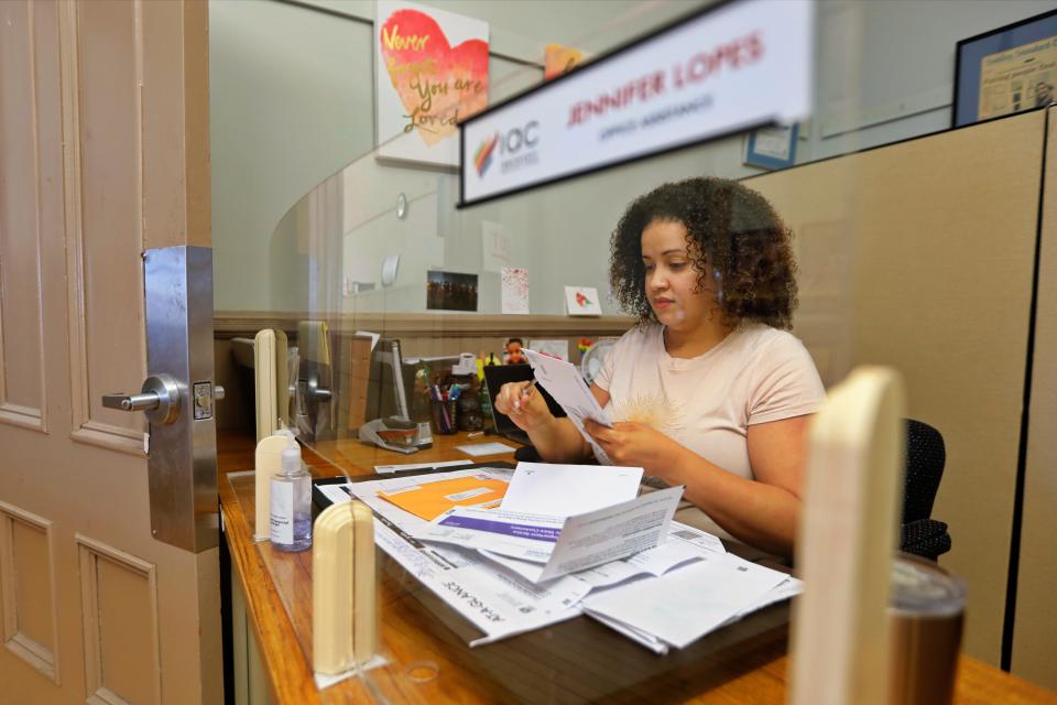 Jennifer Lopes checks incoming mail at the Immigrants Assistance Center on the second floor of Casa da Saudade on Crapo Street in New Bedford.