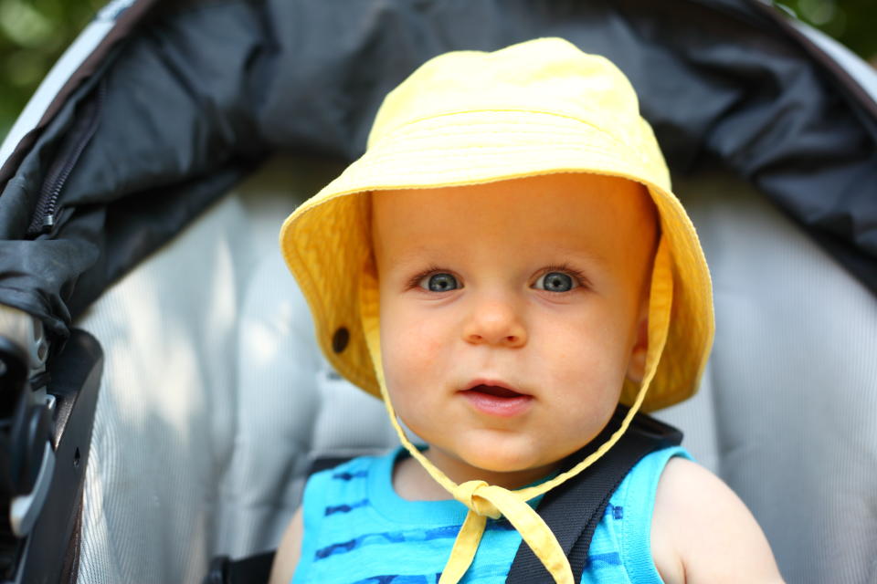 Experts suggest dressing babies in light layers and a hat for sun protection when outdoors. Image via Getty Images.