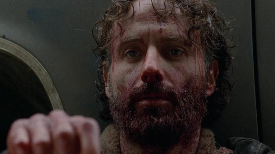 Rick Grimes (Andrew Lincoln) looks devastated after biting an adversary's throat in The Walking Dead.