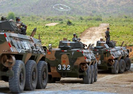 China's army soldiers sit on their tanks as they attend the opening of the "Dragon Gold 2018" military exercise in Kampong Speu province, Cambodia, March 17, 2018. REUTERS/Stringer