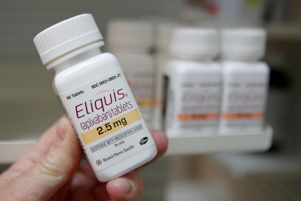 FILE PHOTO: A pharmacist holds a bottle of the drug Eliquis, made by Pfizer Pharmaceuticals, at a pharmacy in Provo