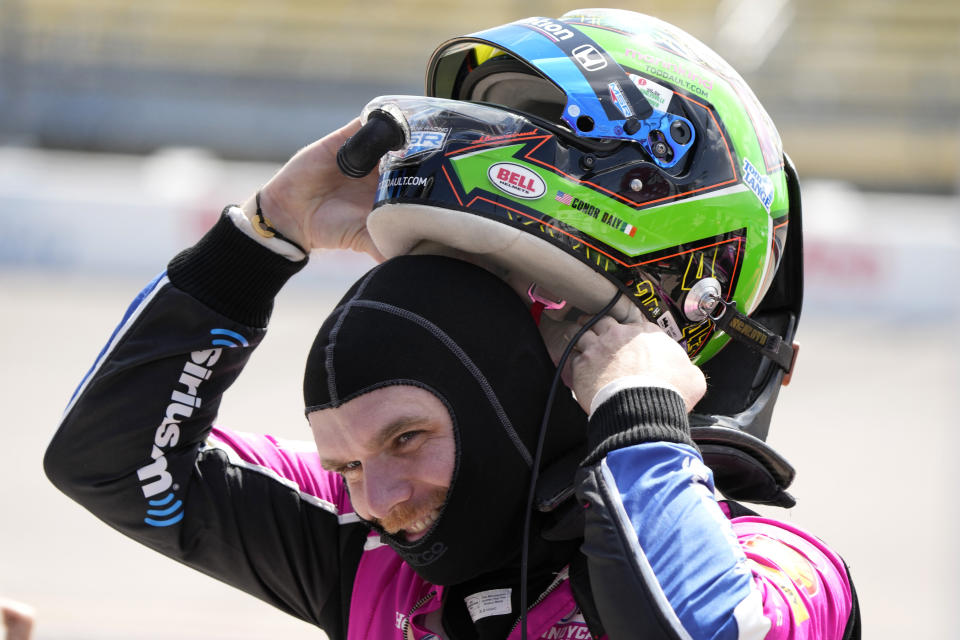 Conor Daly puts on his helmet before practice for an IndyCar Series auto race, Friday, July 21, 2023, at Iowa Speedway in Newton, Iowa. (AP Photo/Charlie Neibergall)