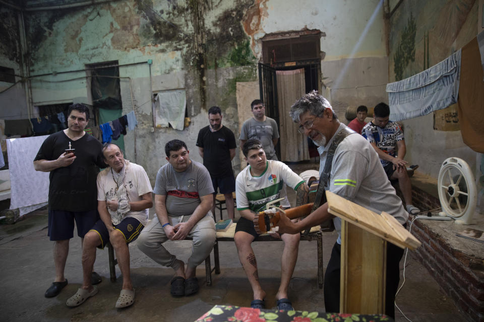 Prisoners listens to a pastor playing a guitar and giving a religious service inside the municipal detention center in Melincue, Santa Fe province, Argentina, Thursday, Dec. 2, 2021. As in other Latin American countries, the spread of evangelical faith in Argentina took root especially in the “most vulnerable sectors, including inmates,” said Verónica Giménez, a researcher at the National Council for Scientific and Technical Research of Argentina. (AP Photo/Rodrigo Abd)