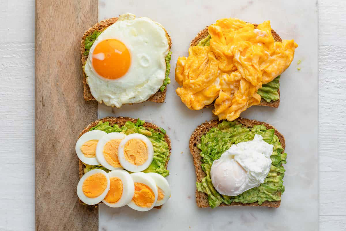 Avocado toast is displayed four ways with eggs.