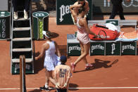 Aryna Sabalenka of Belarus, top right, walks past Ukraine's Elina Svitolina, left, as they change sides during their quarter final match of the French Open tennis tournament at the Roland Garros stadium in Paris, Tuesday, June 6, 2023. (AP Photo/Aurelien Morissard)