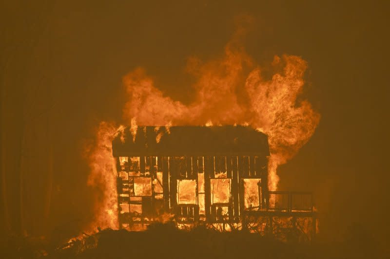 Fire engulfs a small cabin above Highway 50 during the Caldor fire near Lower Echo Lake, Calif., in 2021. Photo by Peter DaSilva/UPI