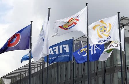 Flags are pictured in front of the headquarters of soccer's international governing body FIFA in Zurich, Switzerland, May 27, 2015. REUTERS/Ruben Sprich