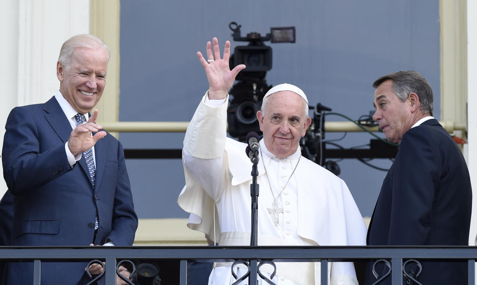FILE - In this Sept. 24, 2015, file photo Pope Francis, flanked by Vice President Joe Biden and House Speaker John Boehner of Ohio, waves to the crowd on Capitol Hill in Washington as they stand on the Speaker's Balcony on Capitol Hill, after the pope addressed a joint meeting of Congress inside. President Joe Biden is set to meet Pope Francis when he visits the Vatican later this month as part of a five-day swing through Italy and the U.K. for global economic and climate change meetings. (AP Photo/Susan Walsh, File)