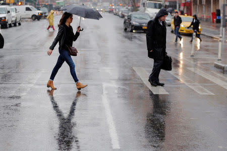 Pedestrians cross a street during a rain shower in New York, U.S., March 1, 2017. REUTERS/Lucas Jackson