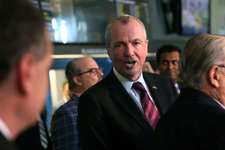 New Jersey Governor Phil Murphy speaks to a colleague before placing the first legal sports bets in the State of New Jersey at Monmouth Park Sports Book by William Hill, on the opening of the first day of legal betting on sports in Oceanport, New Jersey, U.S., June 14, 2018. REUTERS/Mike Segar