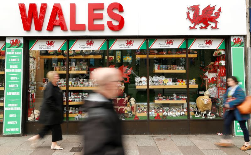 FILE PHOTO: People walk past a souvenir shop in Cardiff