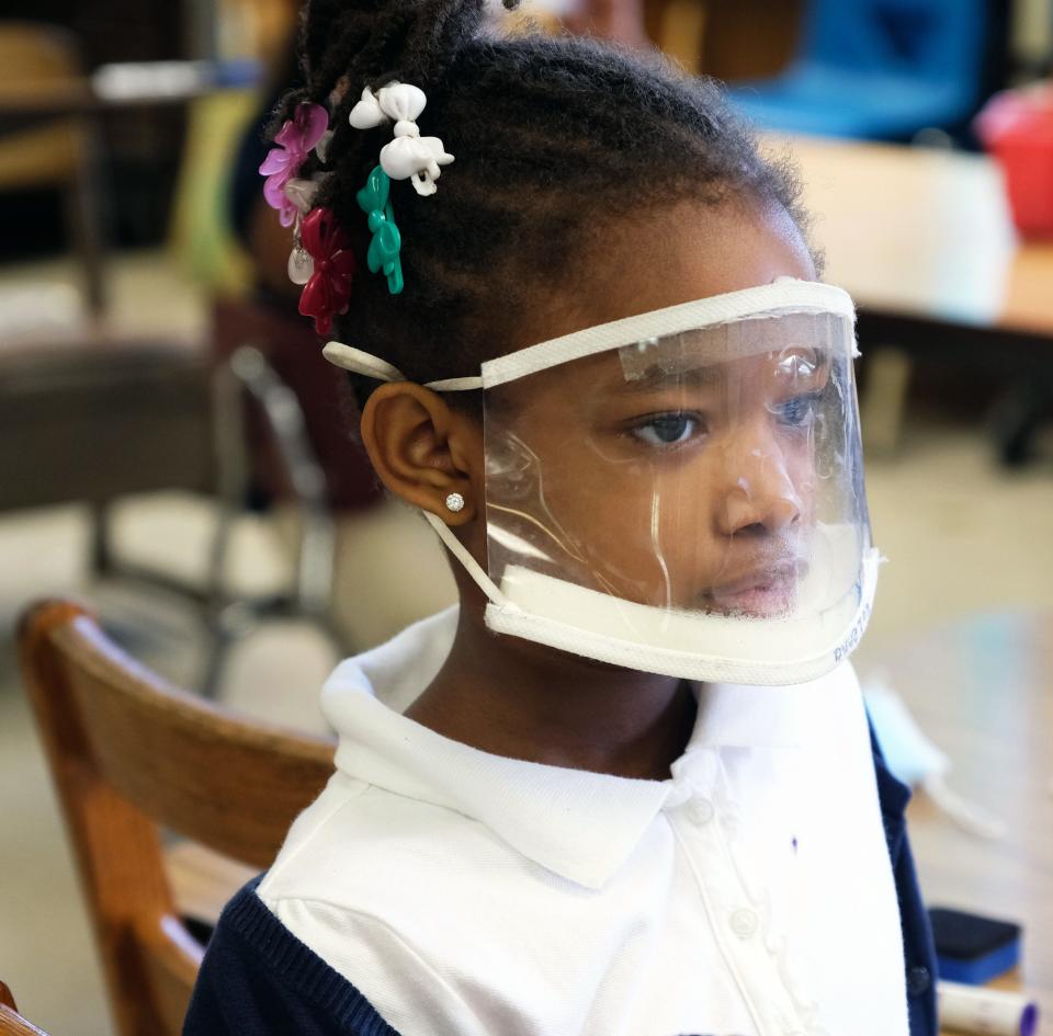 During intervention time at Baker Elementary, students are split into groups led by the teacher and teaching assistant. They both wear face shields, so the students can see the mouthing of each sound.