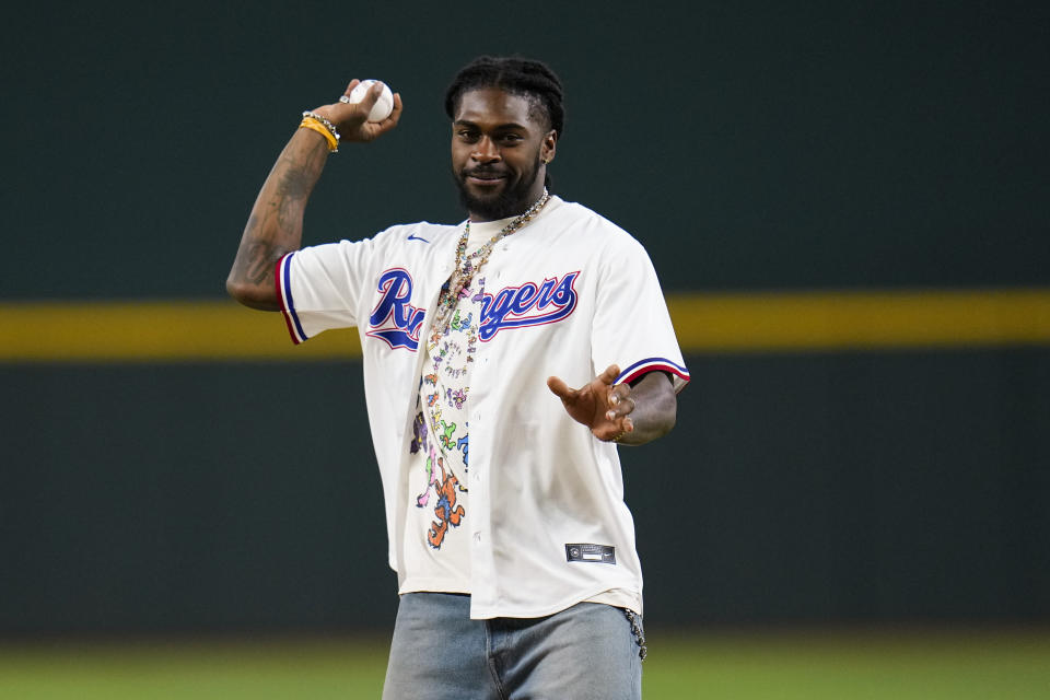 Dallas Cowboys' Trevon Diggs throws a ceremonial first pitch prior to a baseball game between the Texas Rangers and the Boston Red Sox, Tuesday, Sept. 19, 2023, in Arlington, Texas. (AP Photo/Julio Cortez)