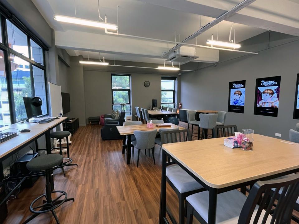 Tables and chairs by the windows in an office space.