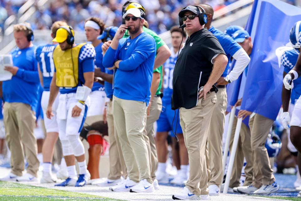 Kentucky offensive coordinator Liam Coen, center, and head coach Mark Stoops, right, watch from the sideline as the Wildcats take on Louisiana-Monroe in a game last September.