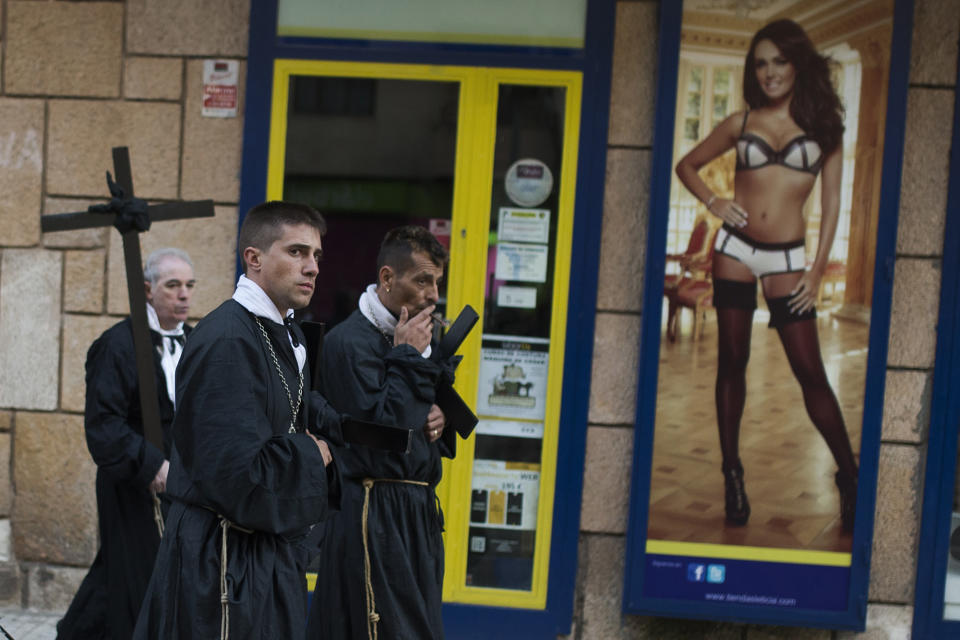 <p>Penitents of the Jesus Nazareno brotherhood pass a lingerie shop during a Holy Week procession in Zamora, Spain, April 18, 2014. (AP Photo/Andres Kudacki) </p>