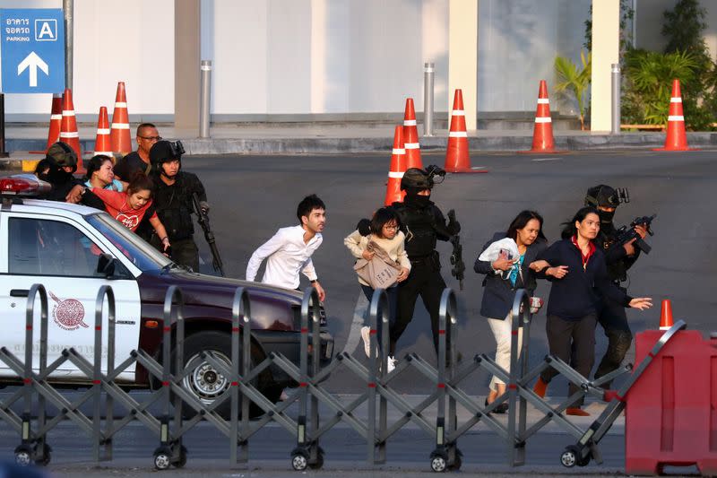 Thai security forces evacuate people who were stranded inside the Terminal 21 shopping mall following a gun battle, to try to stop a soldier on a rampage after a mass shooting, Nakhon Ratchasima