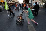 A girl pushes a trolley with a toddler in it in a main market ahead of Yom Kippur, the Jewish Day of Atonement as Israel is set to tighten its second nationwide coronavirus disease (COVID-19) lockdown amid a rise in infections, later today, in Jerusalem