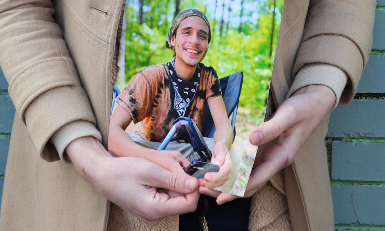 <span>Vienna holds a photo of their slain partner, Tortuguita, in Atlanta, Georgia, on 26 January 2023.</span><span>Photograph: RJ Rico/AP</span>