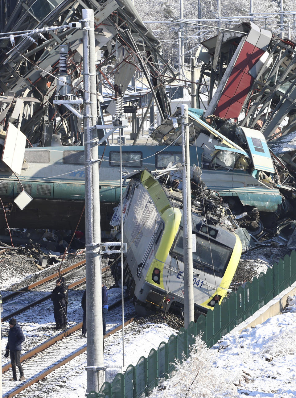 Members of rescue services work at the scene of a train accident in Ankara, Turkey, Thursday, Dec. 13, 2018. A high-speed train hit a railway engine and crashed into a pedestrian overpass at a station in the Turkish capital Ankara on Thursday, killing more than 5 people and injuring more than 40 others, officials and news reports said. (AP Photo/Burhan Ozbilici)