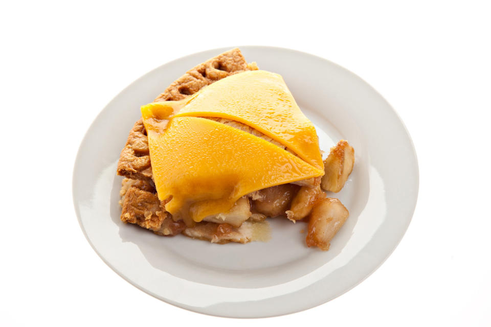 slice of cheese on top of an apple pie slice