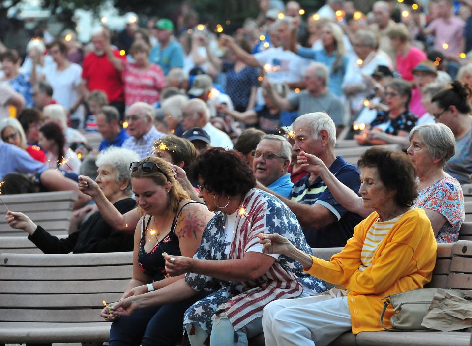 Members of the crowd light sparklers during the playing of “God Bless America” at the Ashland Symphony Orchestra’s annual Pops in the Park Concert Sunday, July 3, 2022 at Guy C. Myers Memorial Bandshell, with new Conductor and Music Director Michael Repper leading the orchestra.