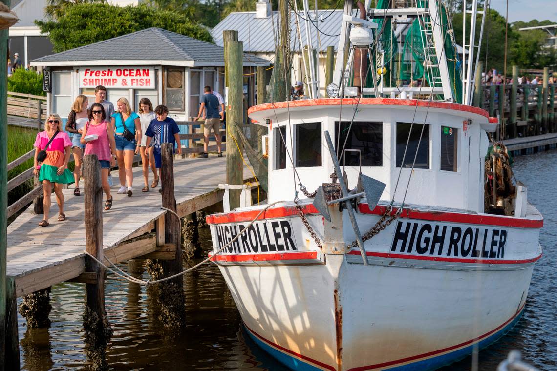 Vacationers stroll the docks of Calabash Creek, as they visit the popular fishing village to sample the popular Calabash Seafood restaurants on Wednesday, July 12, 2024 in Calabash, N.C.