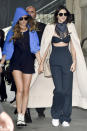 <p>Jenner (seen holding hands with buddy Cara Delevingne) did the Kardashian-approved version of business-wear on her way to Chanel’s spring 2016 show: a super sexy pinstripe jumpsuit with exposed midriff by Alessandra Rich. The model kept things on the casual side, wearing a fringed bandana around her neck and white tennis shoes. She threw a long, cream-colored trench over her outfit, worn cape-style. </p>