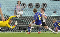 Japan's Ritsu Doan scores his side's first goal against Germany's goalkeeper Manuel Neuer, left, during the World Cup group E soccer match between Germany and Japan, at the Khalifa International Stadium in Doha, Qatar, Wednesday, Nov. 23, 2022. (AP Photo/Matthias Schrader)