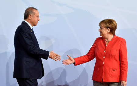 FILE PHOTO: German Chancellor Angela Merkel greets Turkey's President Recep Tayyip Erdogan at the beginning of the G20 summit in Hamburg, Germany, July 7, 2017. REUTERS/John MACDOUGALL/POOL/File Photo