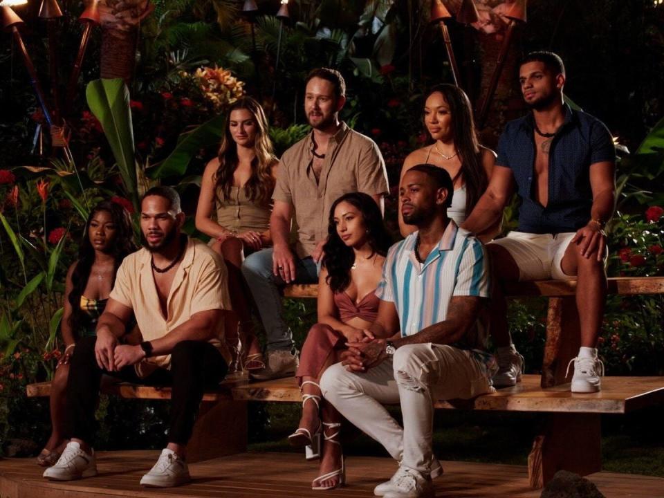 The cast of "Temptation Island" season 5 sits in their couples at their first bonfire.