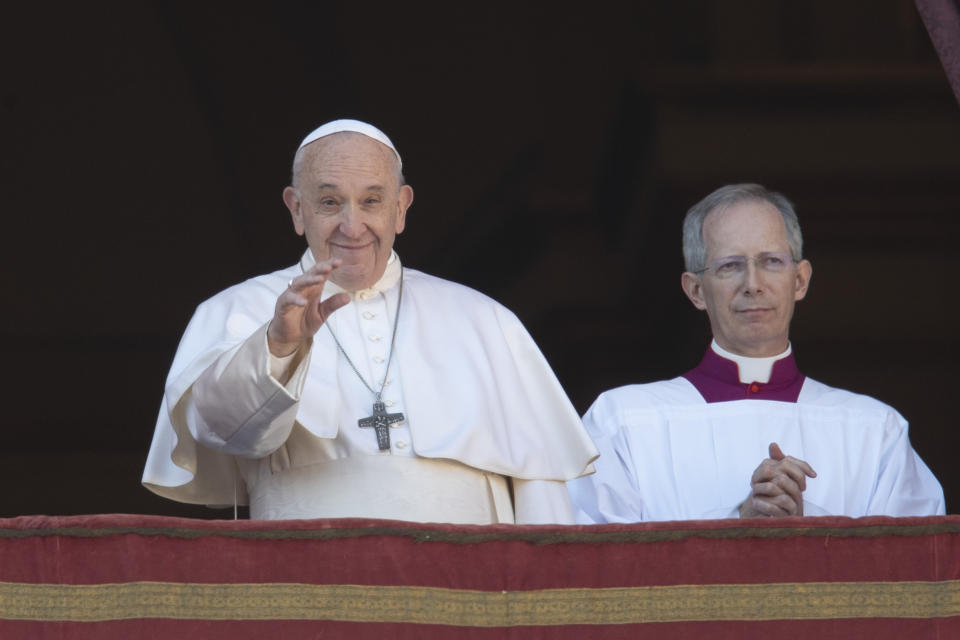 Pope Francis, flanked by Mons. Guido Marini, the Vatican master of liturgical ceremonies, waves to faithful and pilgrims after he delivered the Urbi et Orbi (Latin for 'to the city and to the world' ) Christmas' day blessing from the main balcony of St. Peter's Basilica at the Vatican, Wednesday, Dec. 25, 2019. (AP Photo/Alessandra Tarantino)