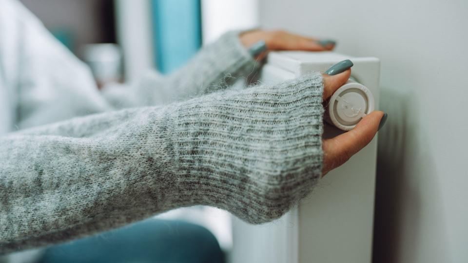 Heating hack that will save you £100+ - woman turning down radiator valve