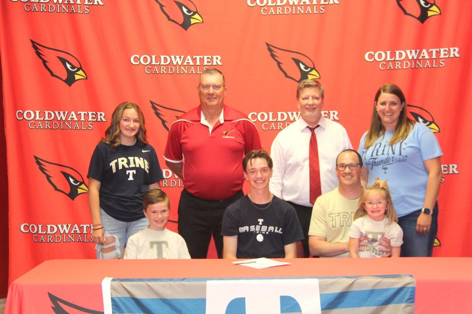 Coldwater's Joseph Closson (center), surrounded by family and coaches, signs his letter of intent to play baseball at Trine University