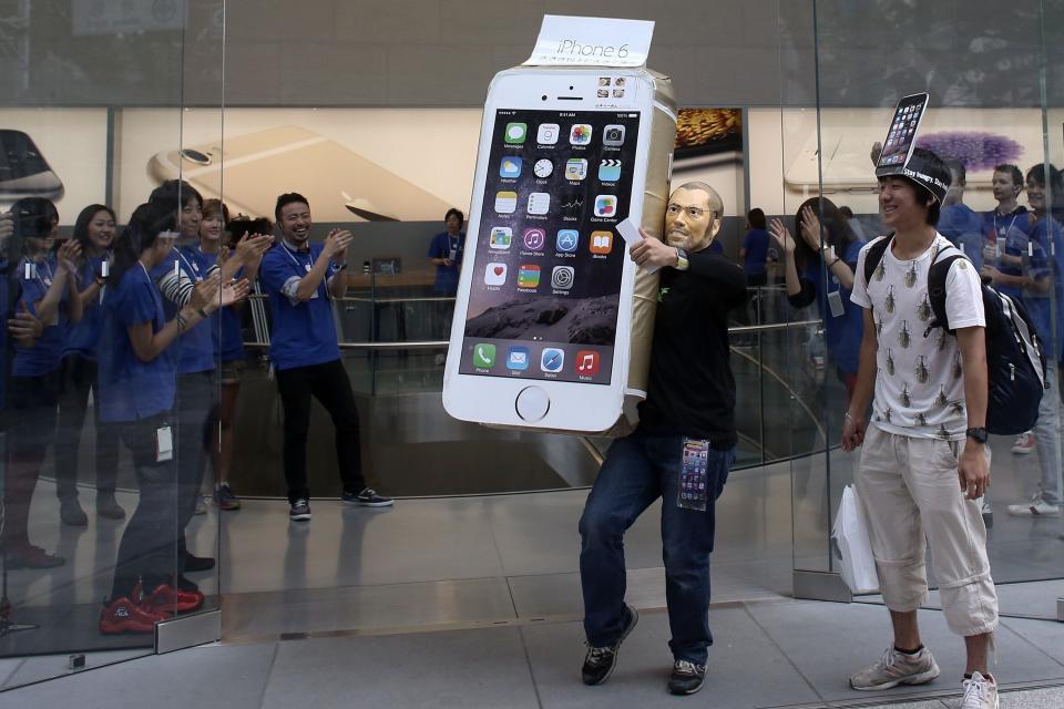 A customer wearing a Steve Jobs mask celebrates after purchasing a new iPhone at the launch of the new Apple iPhone 6 and iPhone 6 plus at the Apple Omotesando store on September 19, 2014 in Tokyo, Japan.