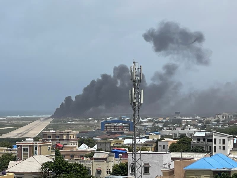 Smoke billows from a plane that flipped over after a crash landing, in Mogadishu