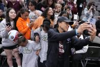 South Carolina head coach Dawn Staley takes a selfie with fans after a practice session for an NCAA Women's Final Four semifinals basketball game Thursday, March 30, 2023, in Dallas. (AP Photo/Tony Gutierrez)