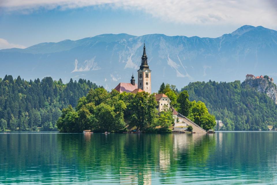 beautiful lake bled in slovenia church dedicated to the assumption of mary santa maria church with surrounding houses and clock tower in the middle of small islet in the famous slovenian lake alps in the background lake bled, slovenia, europe