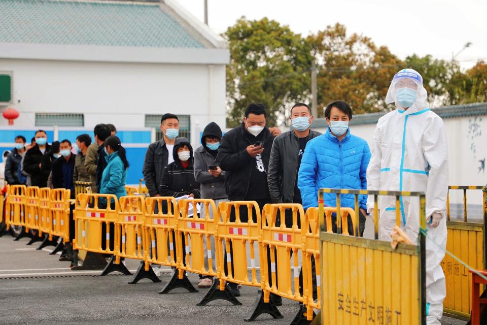 In this photo released by Xinhua News Agency, volunteers carry daily necessities for residents in Fengxian District in eastern China&#39;s Shanghai city on March 28, 2022. China began its most extensive coronavirus lockdown in two years Monday to conduct mass testing and control a growing outbreak in Shanghai as questions are raised about the economic toll of the nation&#39;s &quot;zero-COVID&quot; strategy.