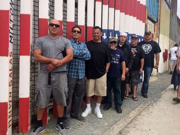 PHOTO: Alex Murillo is seen (right) standing front of the mural project dedicated to deported veterans. (Courtesy Alex Murillo)