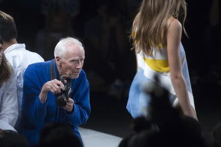 New York Times photographer Bill Cunningham takes photos as a model presents a creation from the Lacoste Spring/Summer 2015 collection during New York Fashion Week in the Manhattan borough of New York September 6, 2014. REUTERS/Carlo Allegri/Files