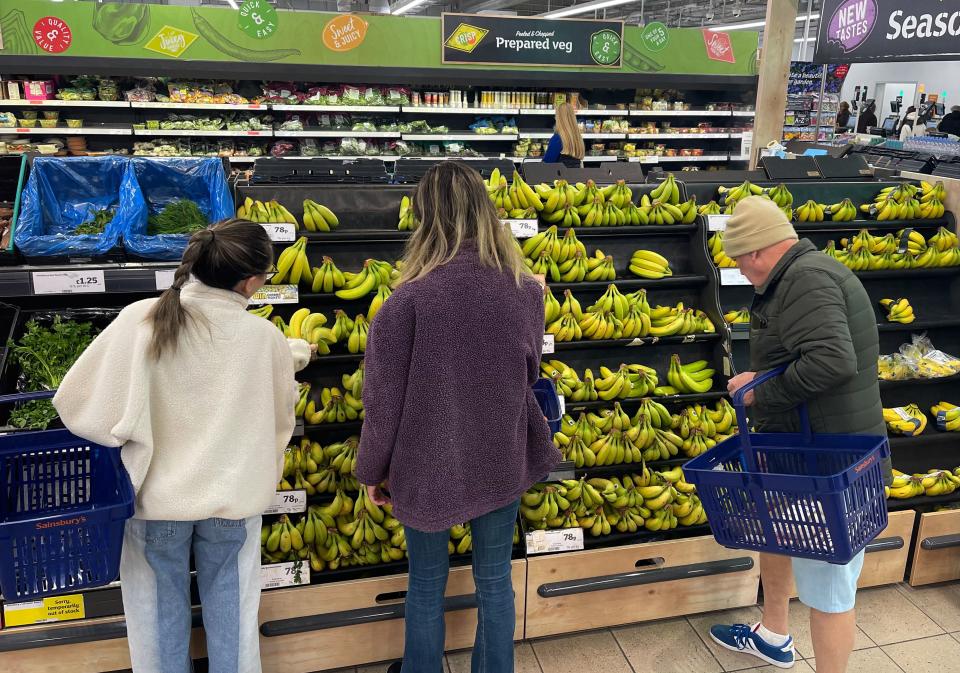 Customers shop for bananas in the fruit and vegetable section of a Sainsbury's supermarket in east London on February 20, 2023. - British retail sales rebounded surprisingly in January on falling fuel costs and discounting by online and physical stores, official data showed Friday. At the same time, food sales dropped 0.5 percent, the ONS said, following large price rises over the past year. (Photo by Daniel LEAL / AFP) (Photo by DANIEL LEAL/AFP via Getty Images)