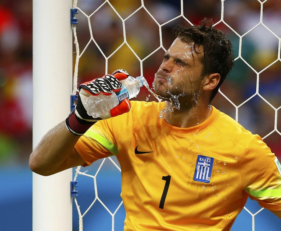 Greece's goalkeeper Orestis Karnezis splashes water on himself during their 2014 World Cup round of 16 game against Costa Rica at the Pernambuco arena in Recife June 29, 2014. REUTERS/Tony Gentile