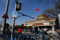 A sign notifying the area is under video surveillance is pictured in a pole with a security camera overlooking the sidewalk in front of the National Art Museum of China in Beijing